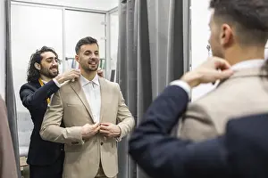 Professional Tailor Service Drucke: A tailor skillfully adjusts a client suit jacket in a fitting room