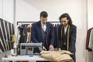 Sewing Tools Drucke: Tailor in a suit store work on fabric with precision