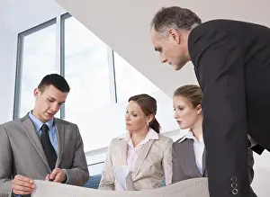 Construction Project Management Drucke: Team of four architects discussing an construction plan