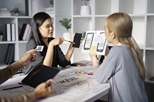 Digital Communication Drucke: A team of designers discussing mobile app prototypes