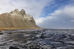 Icelandic Winter Scenery Drucke: Teared water on lava sandy beach against mountain backdrop