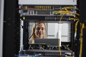 Server Room Technician Drucke: Technician examining server in server room