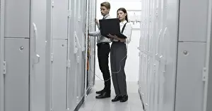 Healthcare Network Drucke: Technicians using laptop while analyzing server in server room