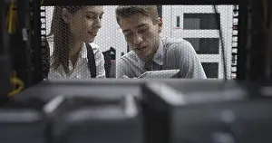 Healthcare Technology Drucke: Technicians using laptop while analyzing server in server room