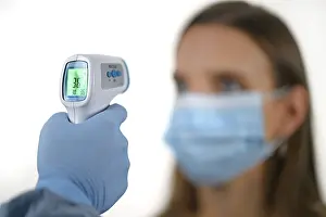 Corona Crisis Germany Drucke: Temperature measurement with forehead thermometer