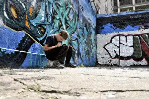 Digitale Kunst Drucke: Zehnjähriger Junge spielt mit seinem Nintendo vor einem Graffitifries.