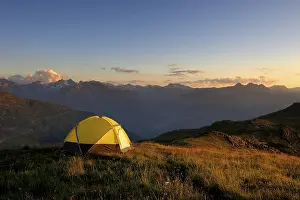 Evening Sun In Austria Drucke: Tent in front of a mountain range in the last daylight