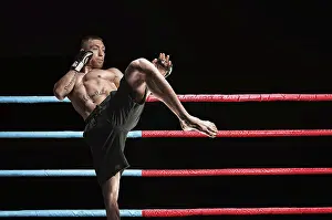 Sports Photography Drucke: Thai boxer in the ring hits with a knee