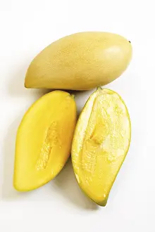 Studio Shot Of Mangos Drucke: Thai mangos, whole and halved