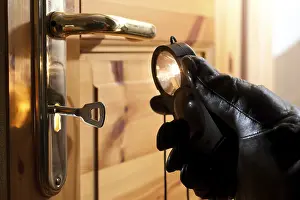 Deserted Castle Entrance Drucke: Thief using a flashlight to examine a door lock