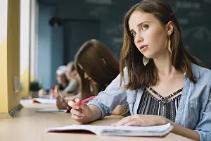 Childhood Education Drucke: Thinking schoolgirl looking camera