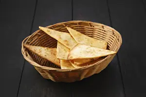 Traditional Breakfast Dish Drucke: Tortilla cut on triangular slices in wicker backet on a table
