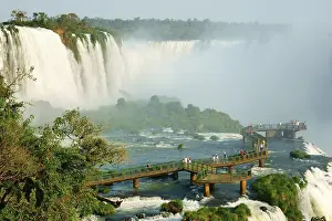 Drucke von Touristen auf einer Aussichtsplattform, Iguazu-Wasserfälle, Foz do Iguaçu, Nationalpark Iguazú, Paraná, Brasilien Touristen auf einer Aussichtsplattform, Iguazu-Wasserfälle Brasiliens Kulturerbestätten Drucke: Touristen auf einer Aussichtsplattform.