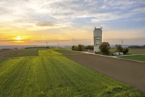 Schwarzwald Evening Atmosphere Drucke: A tower next to fields under an evening sky