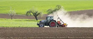 Springtime Agriculture Germany Drucke: Tractor with seed drill in the field in spring
