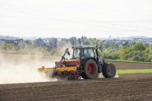 Tractor Seed Drill Drucke: Tractor with seed drill in the field in spring