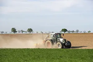 Agricultural Vehicle Europe Drucke: Tractor with seed drill in the field in spring