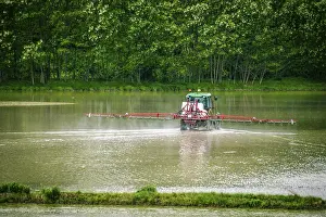 Italian Countryside Scenery Drucke: Tractor working in flooded rice fields