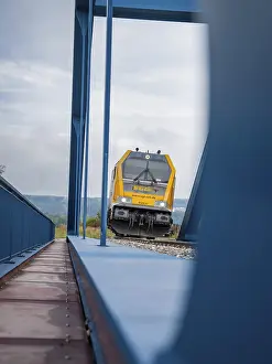 Track Construction Germany Drucke: Train approaching from behind blue subway on rails