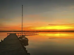 Lower Saxony Nature Park Drucke: Tranquil Dummer See with dock and sailboat at sunset