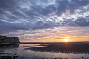 Sandy Ocean Beach Scenery Drucke: A tranquil sunset over a sandy beach