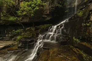 Overgrown With Moss Images Drucke: A tranquil waterfall flows over rocks and moss