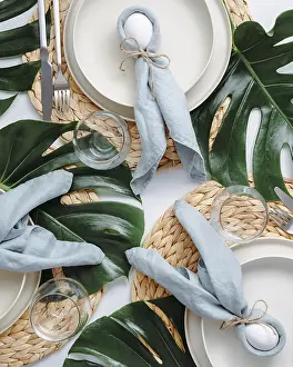 Easter Food Photography Drucke: Tropical Easter Tablesetting. Top view of table setting for Christian Easter with bunny eggs decorated monstera leaves