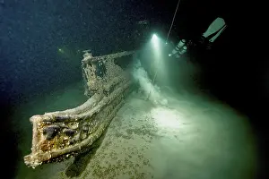 Lake Constance Dive Site Drucke: Underwater image of a diver approaching a shipwreck with a light source
