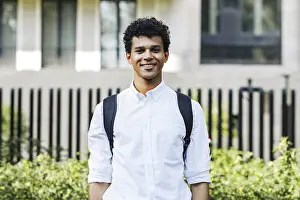 Teenager Looking At Camera Drucke: University student standing in front of a tree and looking at camera