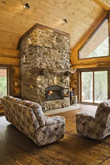 Log Cabin Interior Drucke: Upholstered sofas with lit fieldstone
