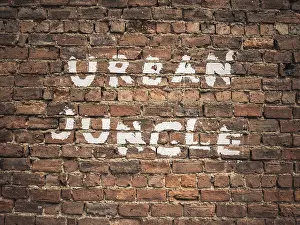 Landschaftsmalerei Drucke: Urban Jungle geschrieben als Graffiti auf einem alten roten Backsteinmauer.