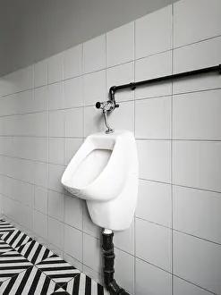 Clean Bathroom Interior Drucke: A urinal is mounted on a wall in a restroom