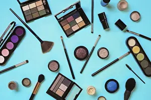 Blue Background Cosmetics Drucke: Various cosmetics and brushes on blue background