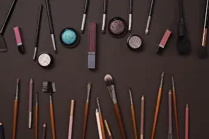 Glamour Beauty Accessories Drucke: Various cosmetics and brushes on brown background