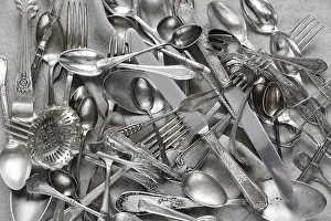 Empty Dining Table Setup Drucke: Various silverware on a background of gray linen fabric