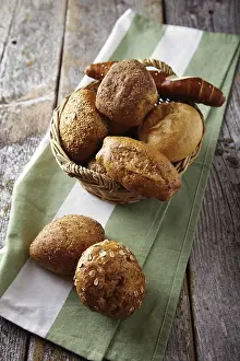 Freshly Baked Goods Drucke: Various types of bread in a basket lying on a rustic table