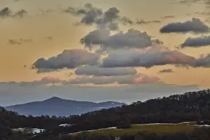 Atmospheric Evening Light Shot Drucke: Vegetation of forests and fields in the hills with clouds in evening light