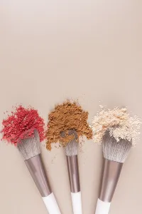 Makeup Brush Drucke: Top vertical view of three makeup brushes with samples of loose makeup textures