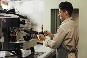 Hot Beverage Drucke: Side view of a barista using a coffee machine