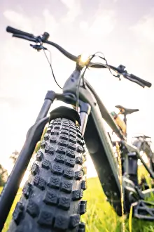 Electric Bicycle Europe Drucke: Front view of a bicycle tyre at sunset
