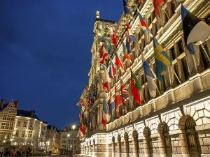 Drucke von Seitenansicht des Rathauses mit Flaggen entlang der Fassade, beleuchtet in der Abenddämmerung, Antwerpen, Belgien Seitenansicht des Rathauses mit Flaggen entlang der Fassade Antwerpen Drucke: Seitenansicht des Rathauses mit Flaggen entlang der Fassade.