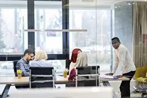 Female Manager At Work Drucke: Back view of co-workers writing documents using laptops at workplace in office