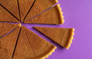 Thanksgiving Dessert Drucke: Above view of a cut pumpkin pie with a slice separated