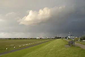 Dark Clouds Over Germany Drucke: View from the dyke towards the harbour