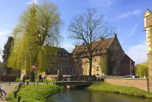 Münsterland Tourist Attraction Drucke: View of the excursion destination Westphalian moated castle Raesfeld in beginning spring with budding trees