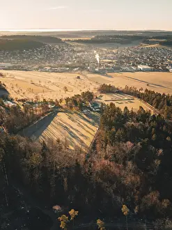 Dusk Landscape Photography Drucke: View over the fields and forests to a town at dusk