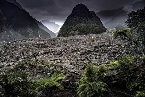 Overcast Sky With Mountains Drucke: View of Fox Glacier with dramatic clouds and green vegetation in the foreground