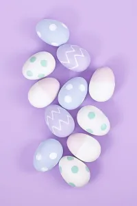 High Angle View Of Easter Eggs Drucke: Top view of group of pastel colored easter eggs on violet background
