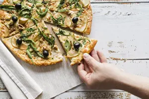 Studio Shot Of Pizza Drucke: Top view hand taking slice pizza