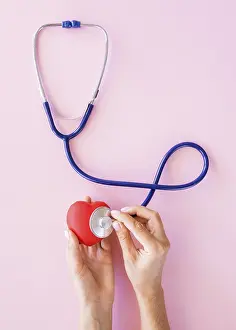 Heart Symbol Concept Drucke: Top view hands checking heart with stethoscope